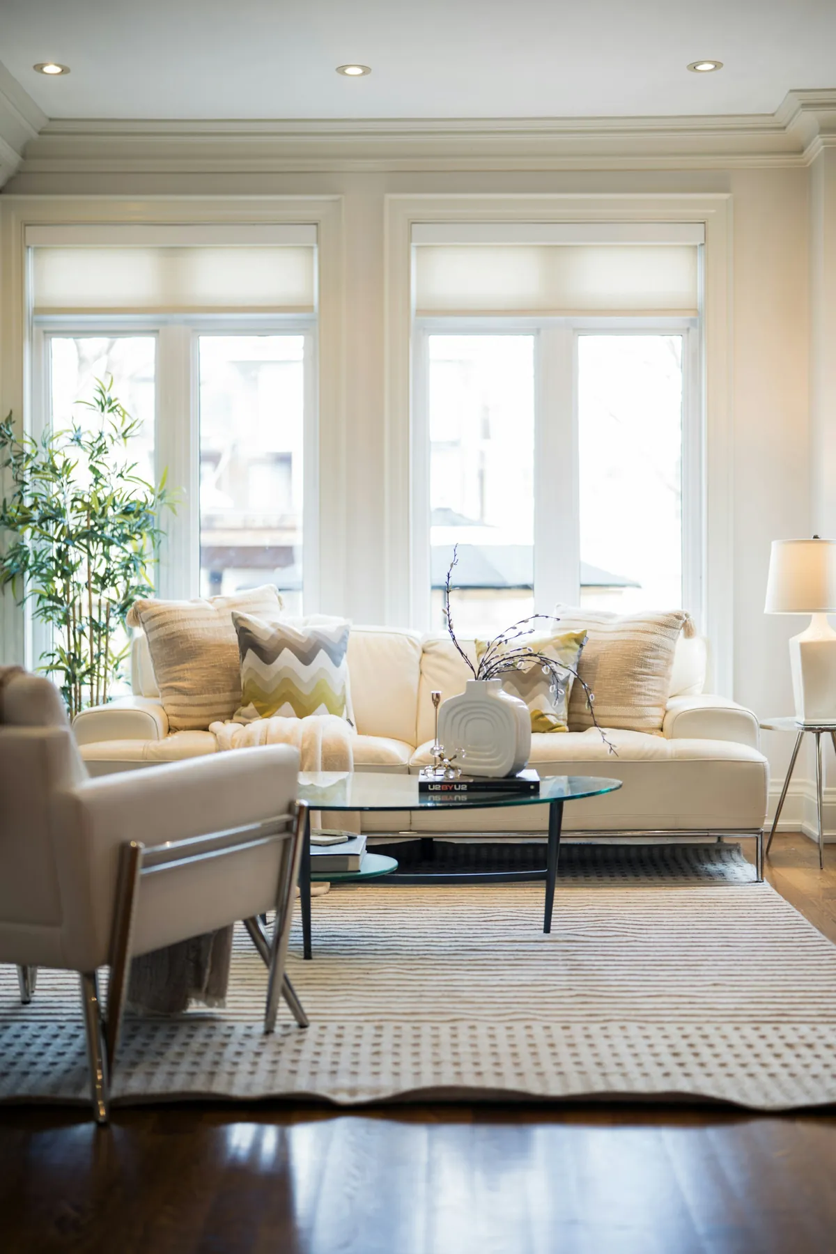 Helles Wohnzimmer mit Sofa, Sessel und grossen Fenstern